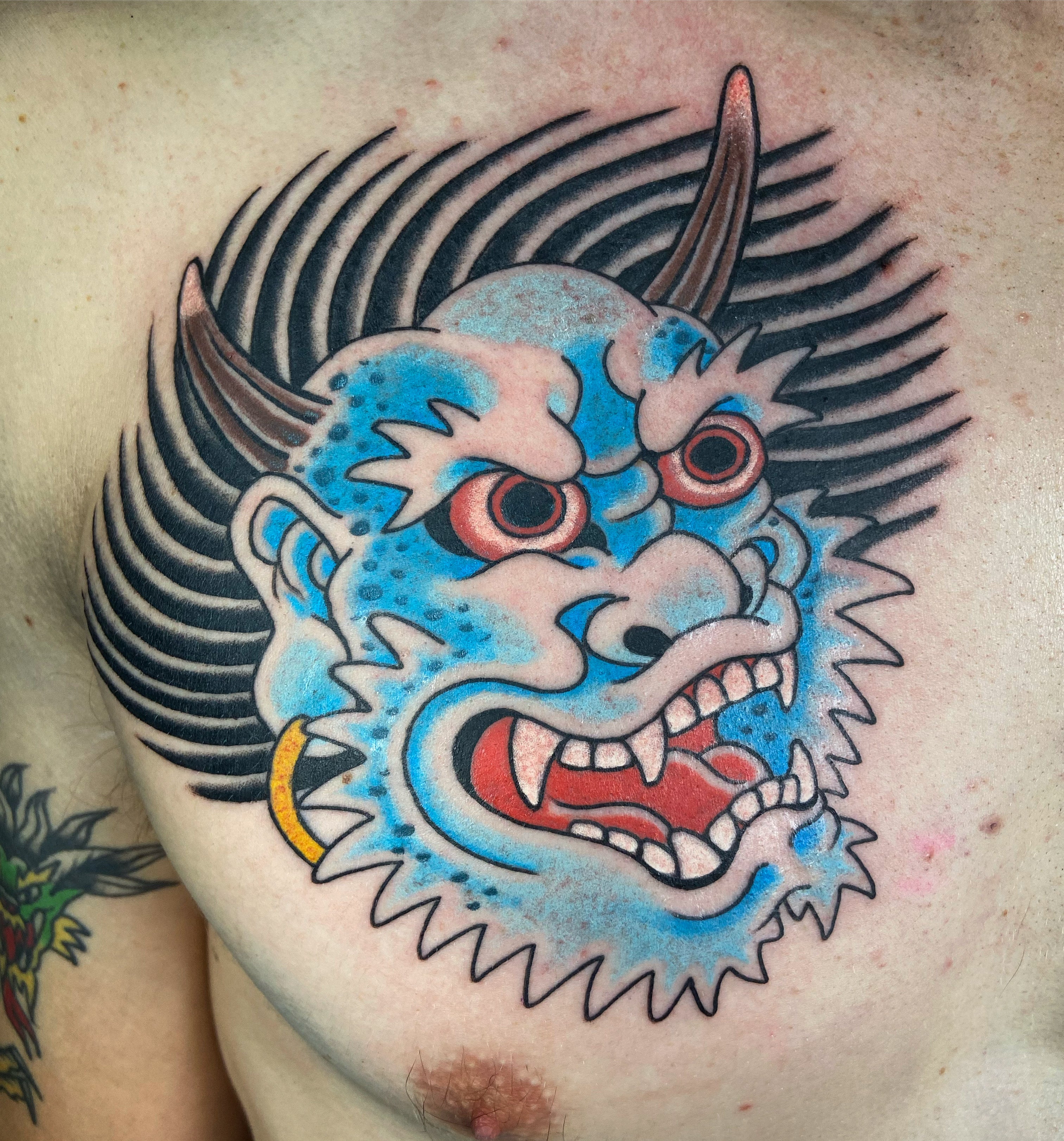 Blue Japanese oni head chest tattoo